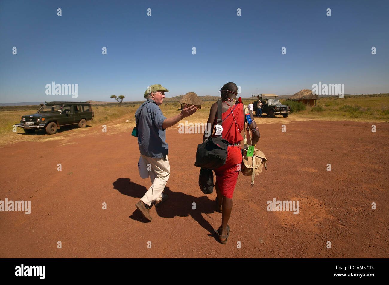 Masai and Peter Bender on the landing strip in Masai Mara near Little Governor s camp Kenya Africa Stock Photo