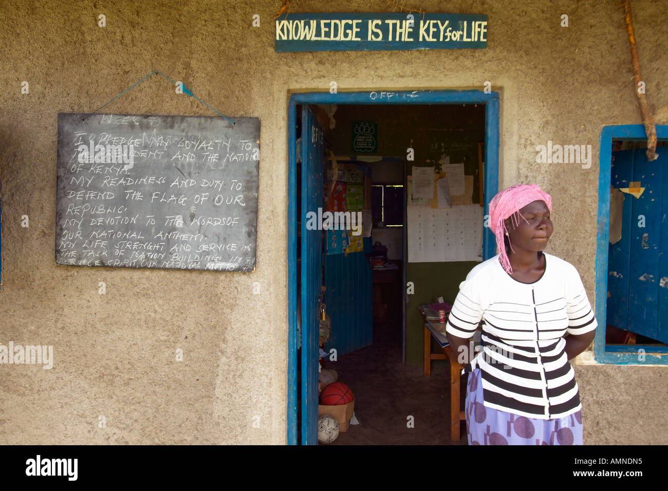 Knowledge is the key for life sign and teacher in front of school house near Tsavo National Park Kenya Africa Stock Photo