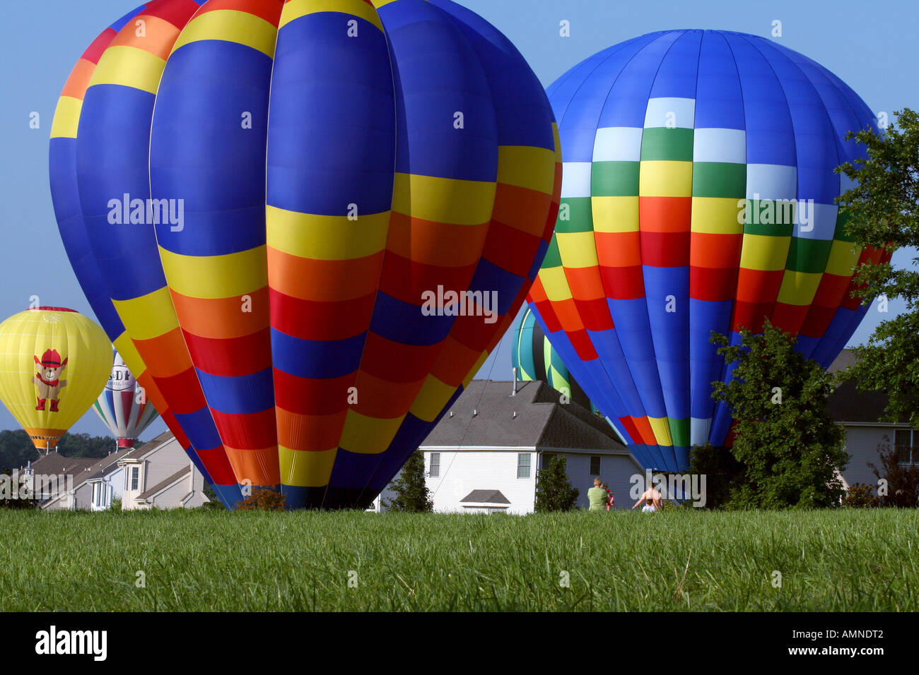 Five balloons landing in and among a group of houses. Stock Photo