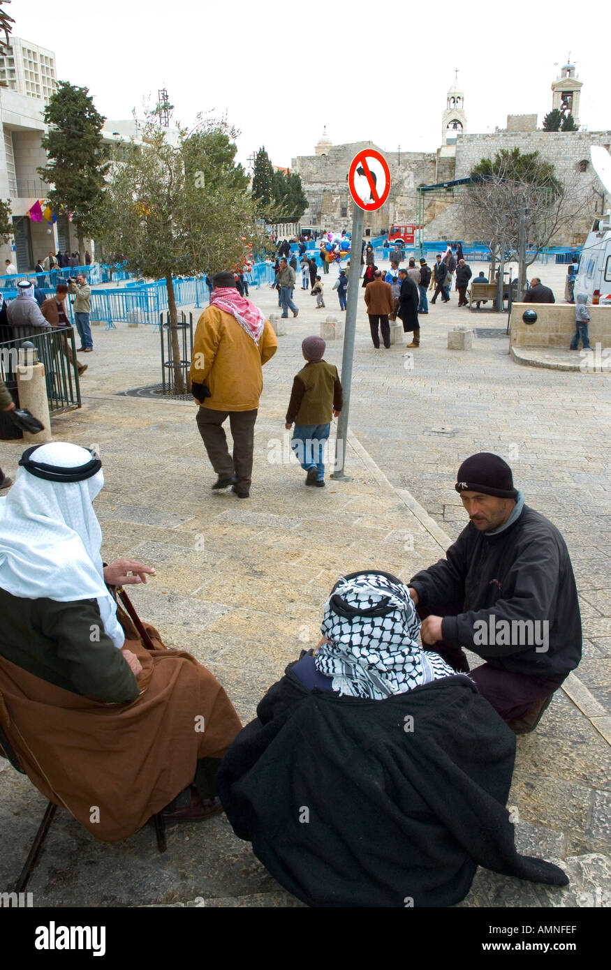 Palestinian Authority Bethlehem Manger Square group of mulem man sitting and talking with church of the nativity in bkgd Stock Photo