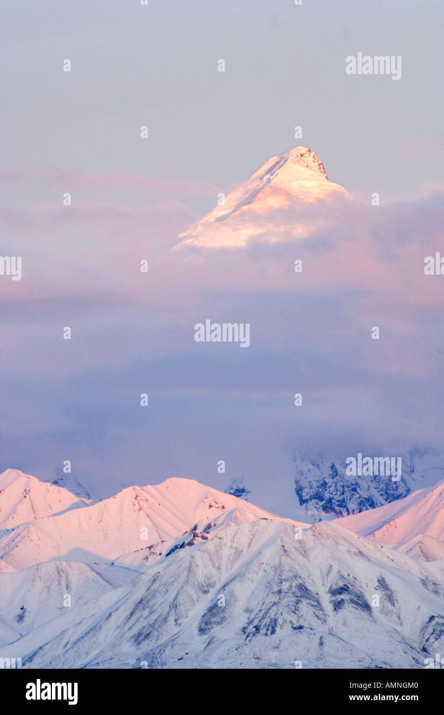 ALASKA DENALI NATIONAL PARK MT BROOKS PEERING THROUGH PINK CLOUDS AT SUNSET NEAR MT  McKINLEY ALASKA RANGE Stock Photo