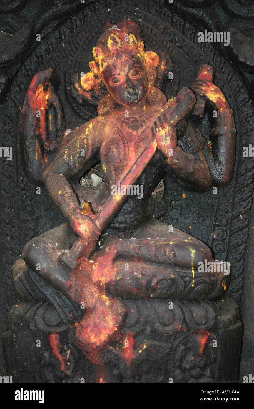 Old relief of the goddess Saraswati covered with red and yellow paint Kathmandu Nepal Stock Photo