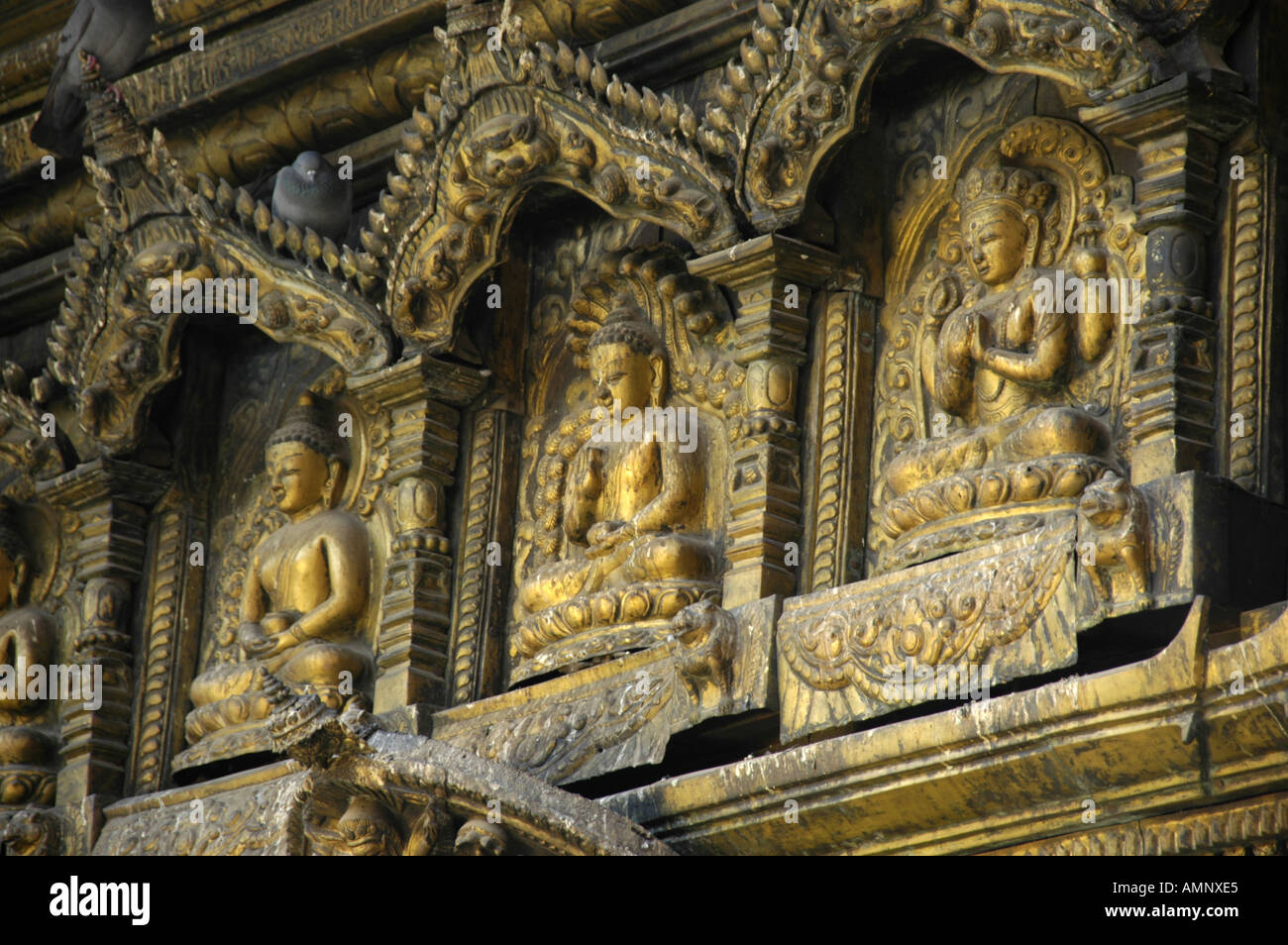 Three images of Buddha in gold Golden Temple Patan Kathmandu Nepal Stock Photo