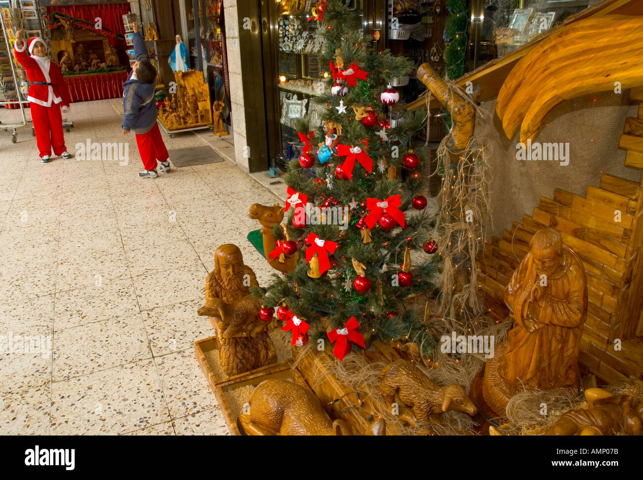 Palestinian Authority Bethlehem Manger Square christian shops young boys palying with xmas creche in frgd  Stock Photo