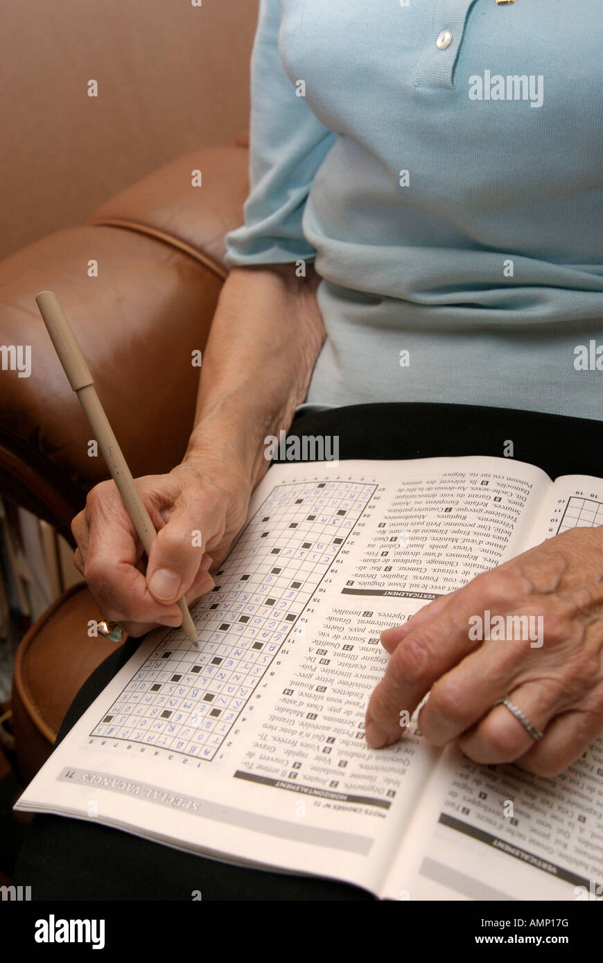 Hands of an elderly woman doing a crossword puzzle Stock Photo