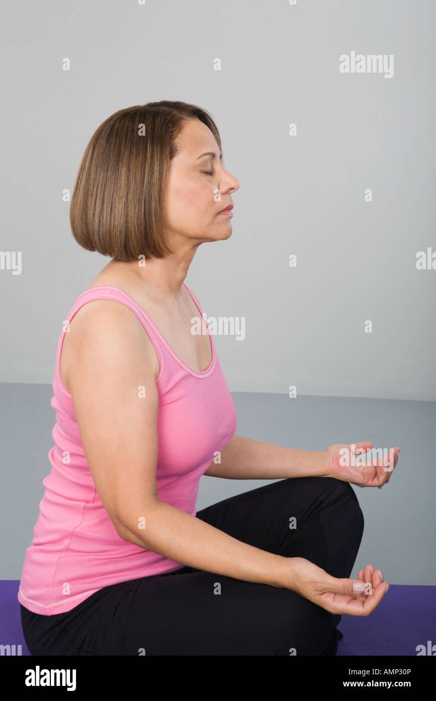 woman meditating on yoga mat Stock Photo - Alamy