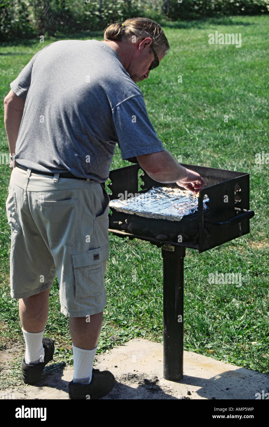 Preparing the grill by punching holes in the aluminum foil before the