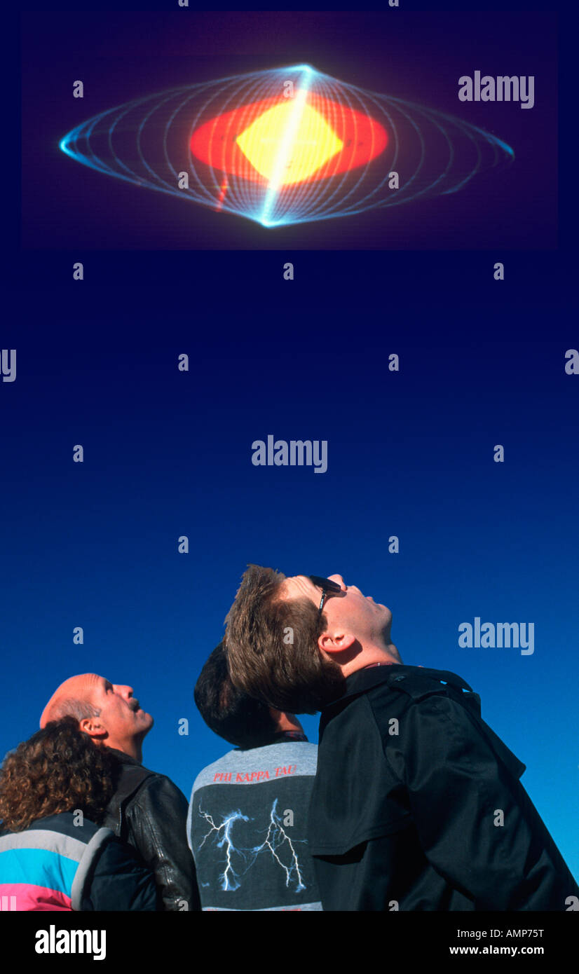 Composite image of spectators looking up at a colorful laser light display in the dark blue sky Stock Photo