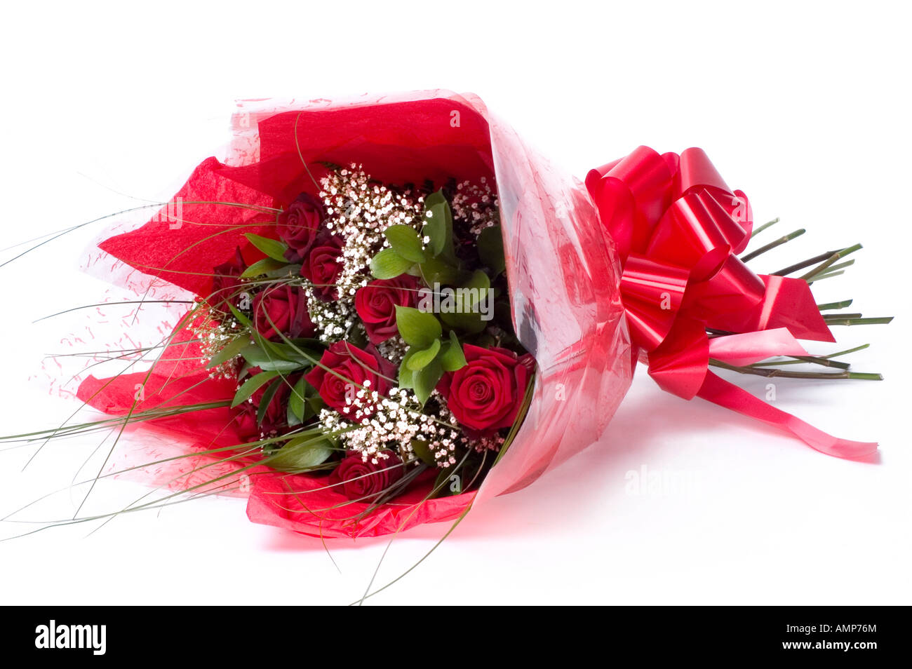 Bouquet of red roses, white angels hair and ferns wrapped in red paper with red ribbon Stock Photo
