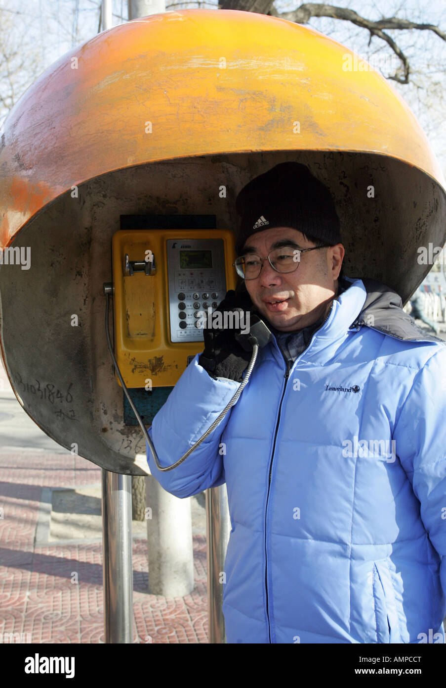 Man using a public telephone box, Beijing, China Stock Photo