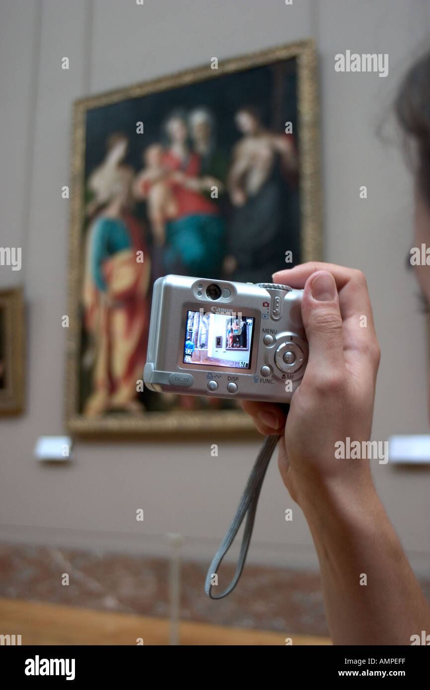 A woman uses a digital camera to document masterpieces at the Louvre in