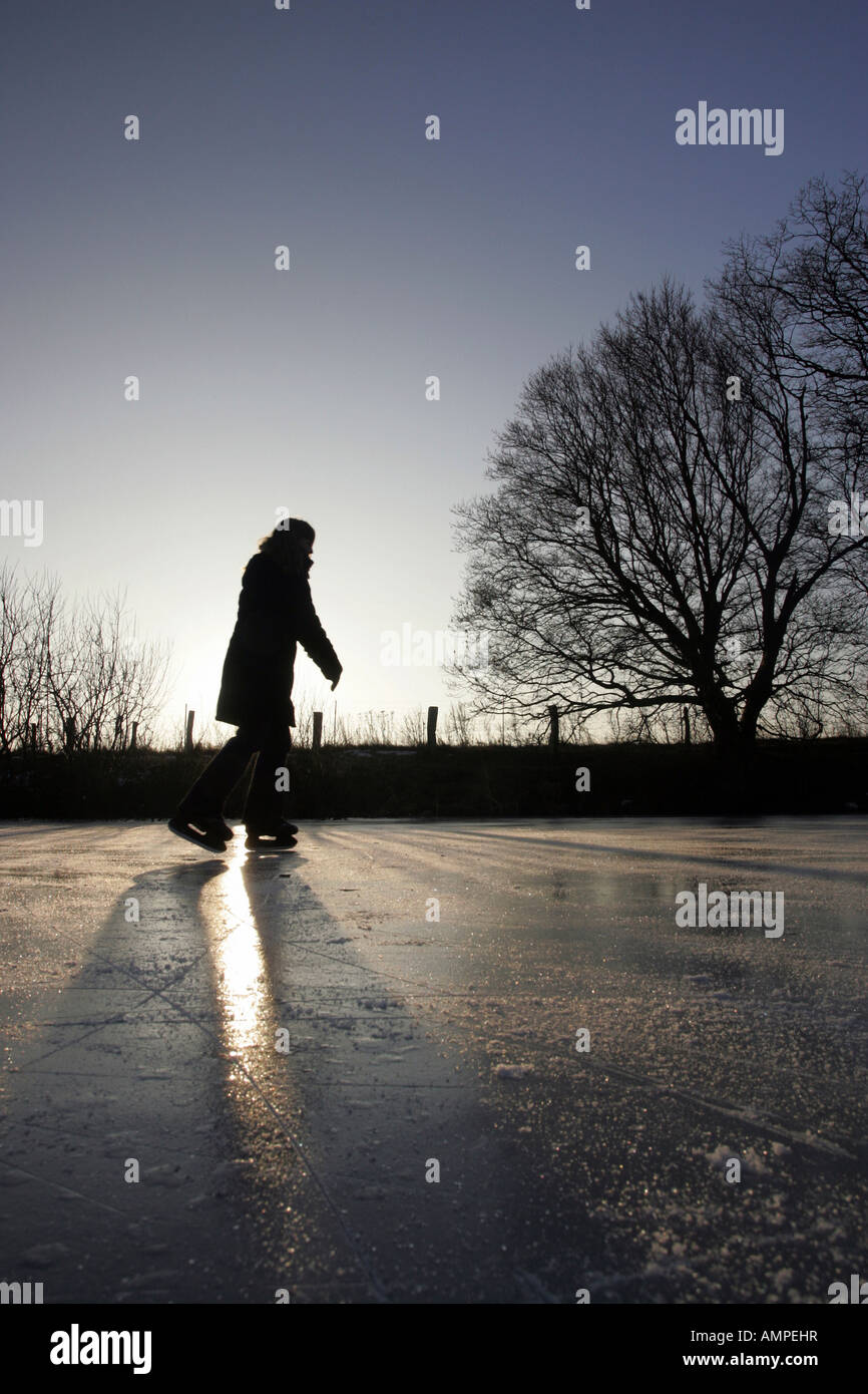Woman skating on a frozen lake Stock Photo