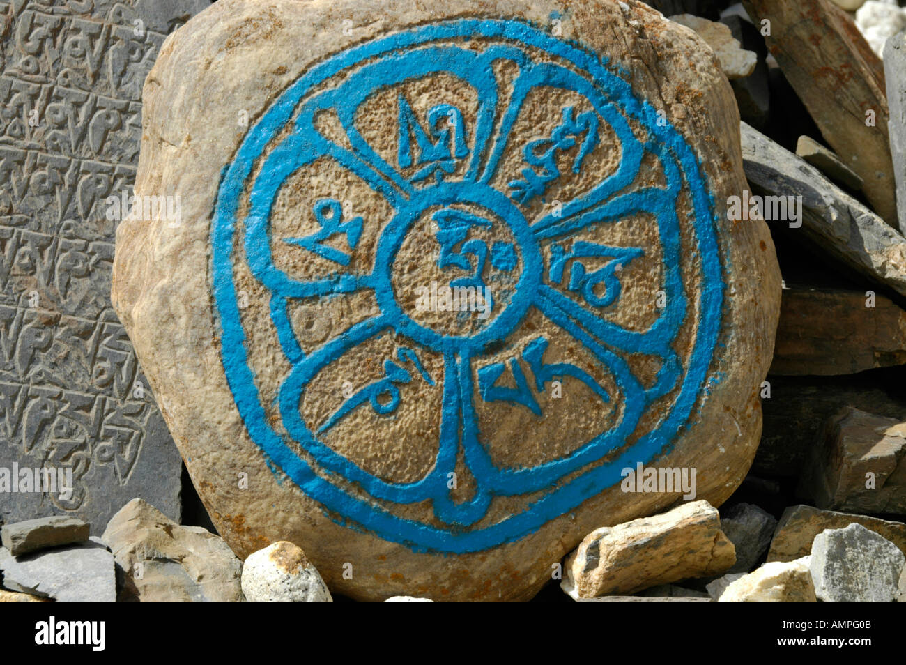 Tibetan script in a circle with turquise colour on a rock Nar Phu Annapurna Region Nepal Stock Photo