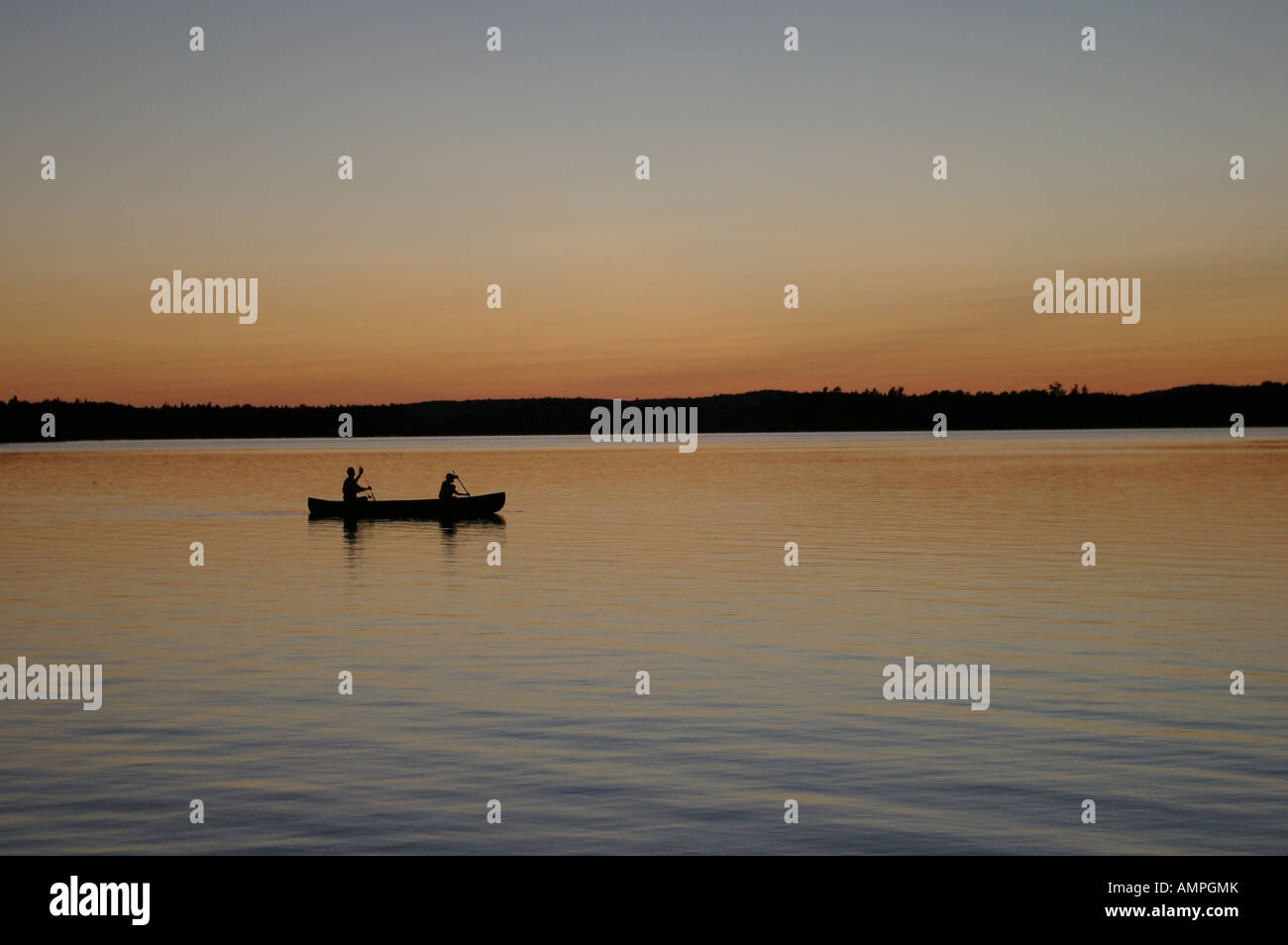 Father and son paddling a canoe at dusk on Long Lake near Princeton, Maine. Stock Photo