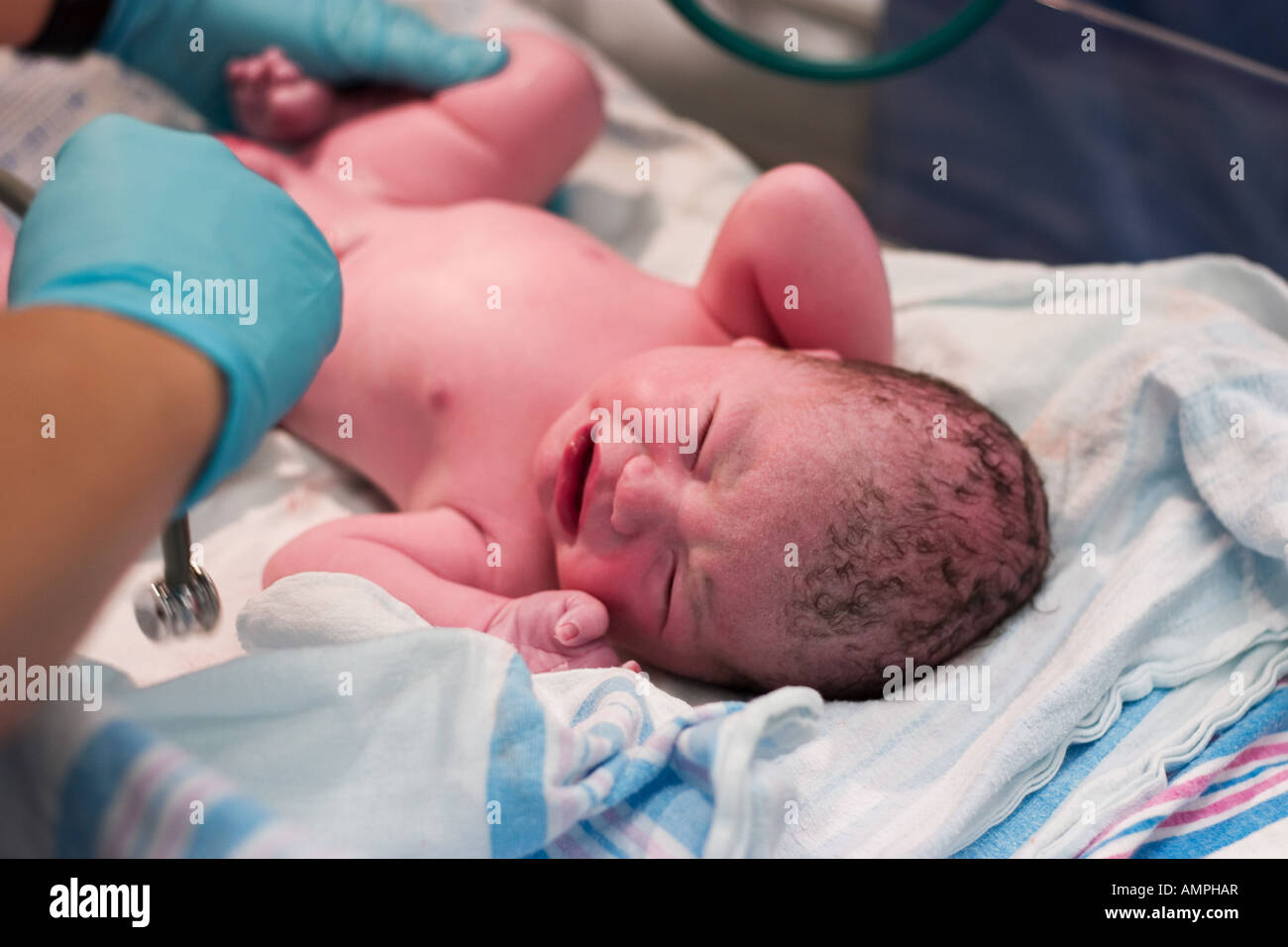 Newborn baby being examined in delivery room Stock Photo