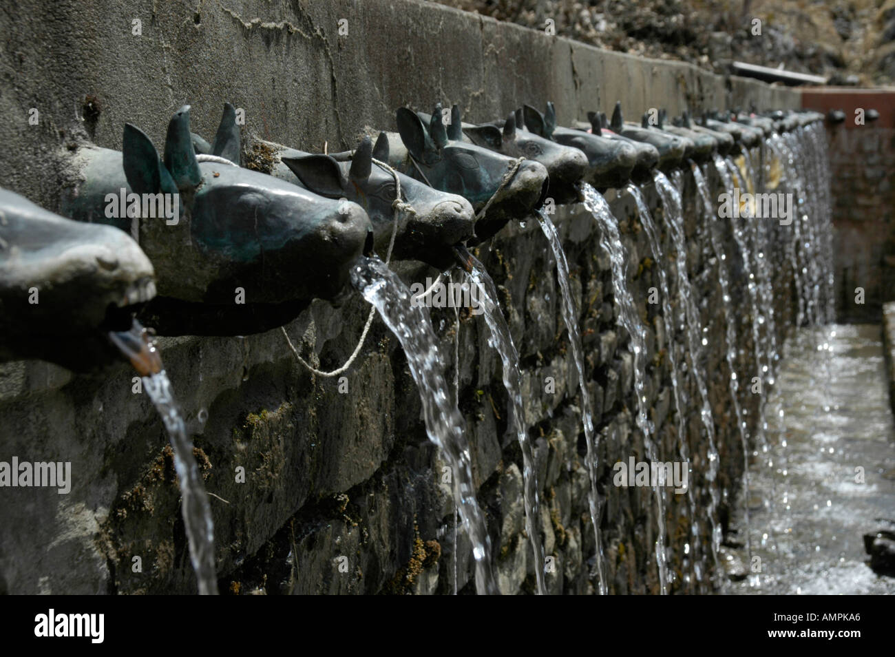 Source water flows out of animal head brass water spouts Vishnu Temple Muktinath Mustang Annapurna Region Nepal Stock Photo