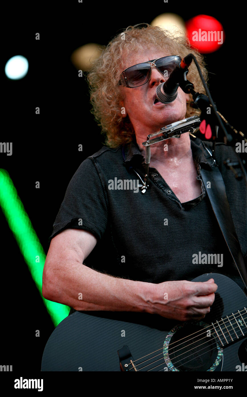 Ian Hunter singing and playing guitar with his band on stage at the