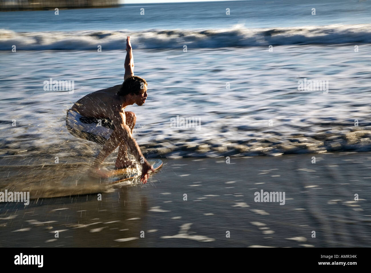 Young man riding a skim board at Pismo Beach, California Stock Photo