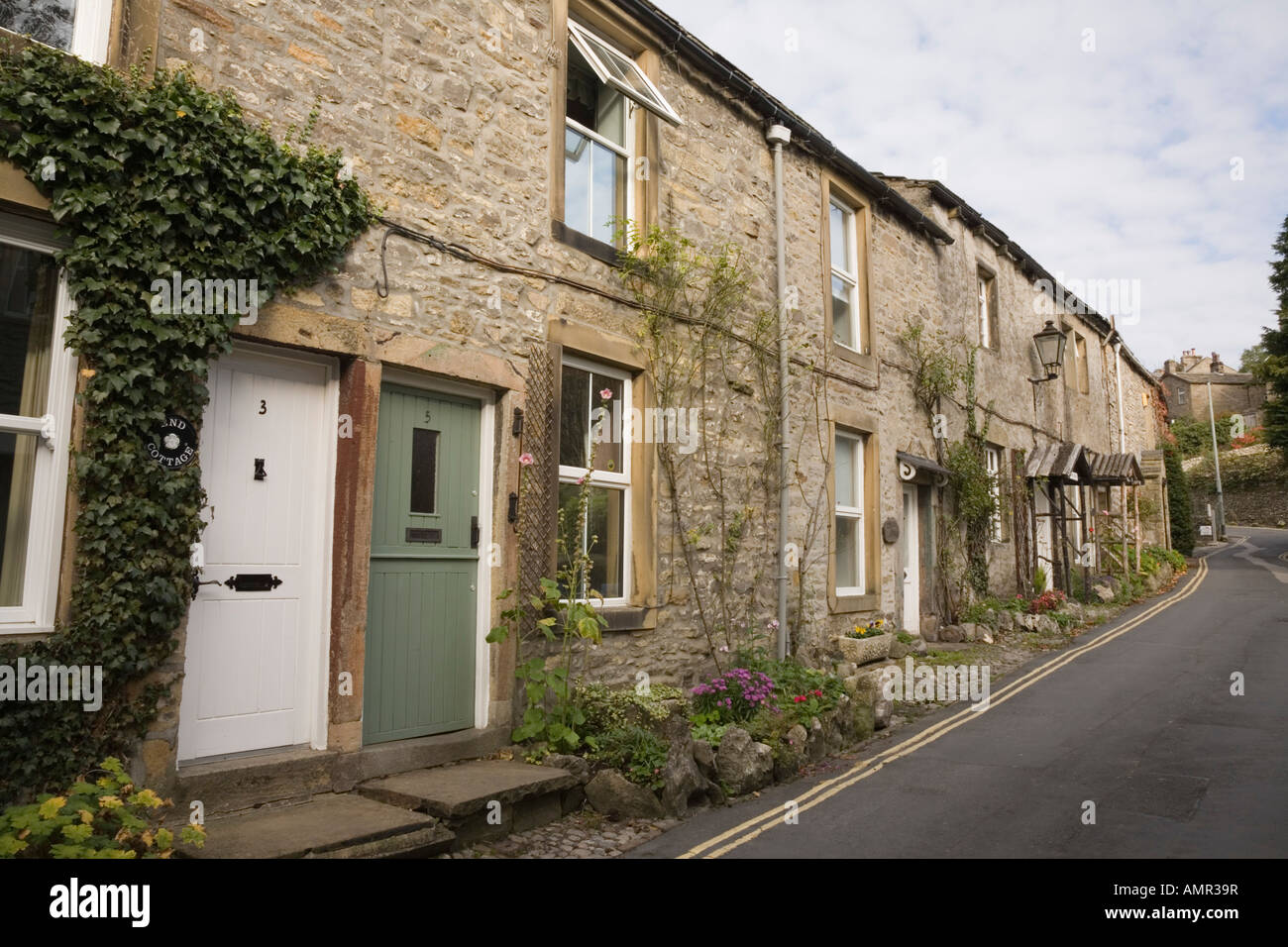 Traditional old stone terraced houses on roadside in village of