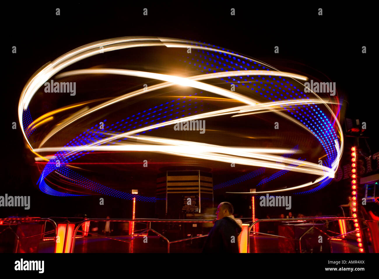 Light trails on fairground ride at night Stock Photo