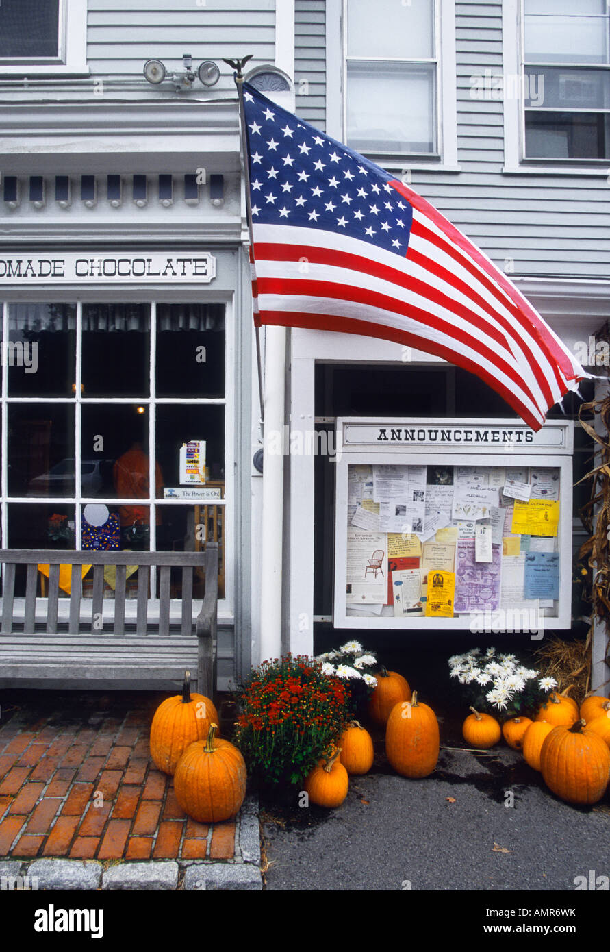 Small town USA country store in the autumn. Pumpkins, American flag, white clapboard house storefront in New England. Americana. Nobody Stock Photo