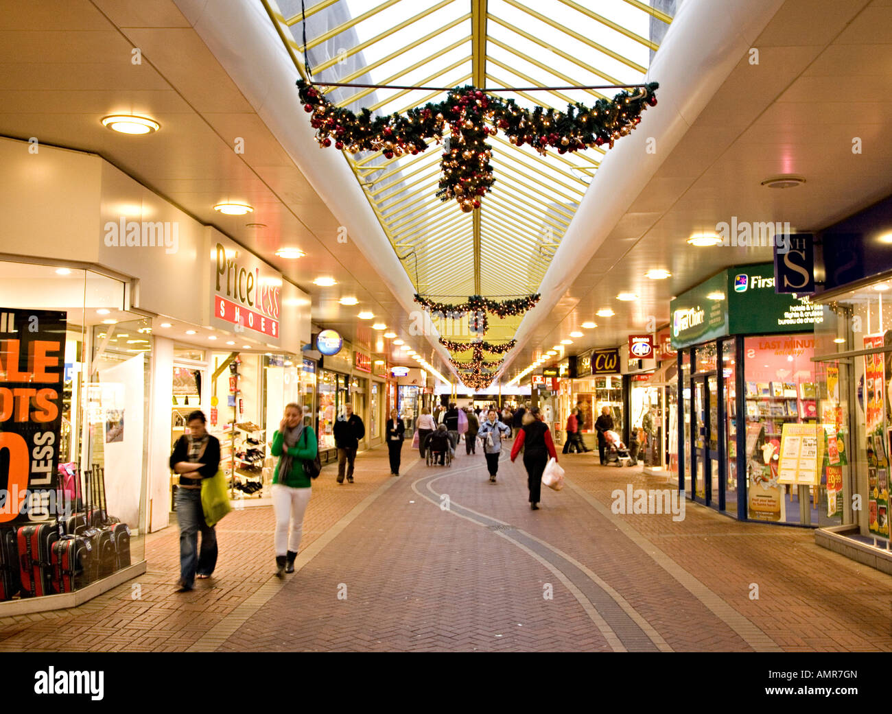 People walking in covered shopping centre with Christmas lights Cwmbran