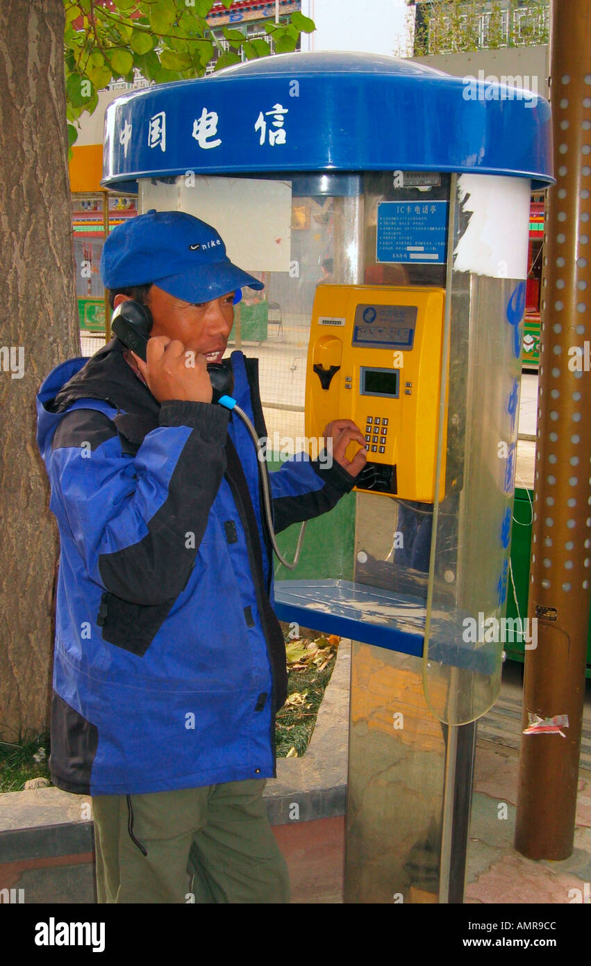 Man using public telephone kiosk Shigatse Tibet Stock Photo