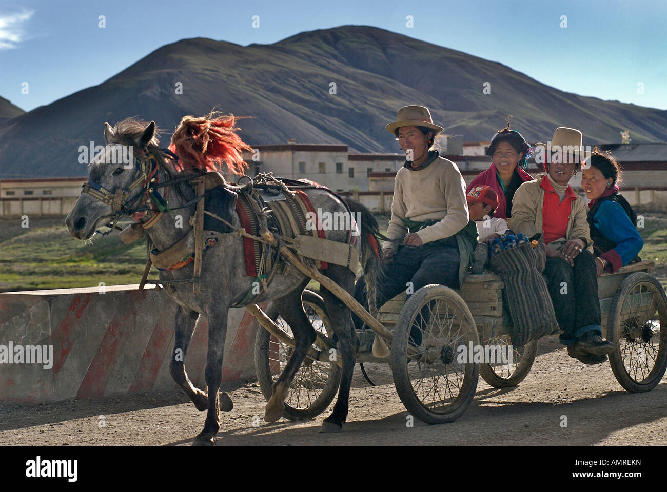 Horse drawn cart taking rural Tibetans into town Shegar Tibet Stock Photo