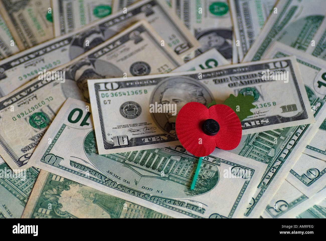Rememberance Poppy on a pile of Dollars Stock Photo