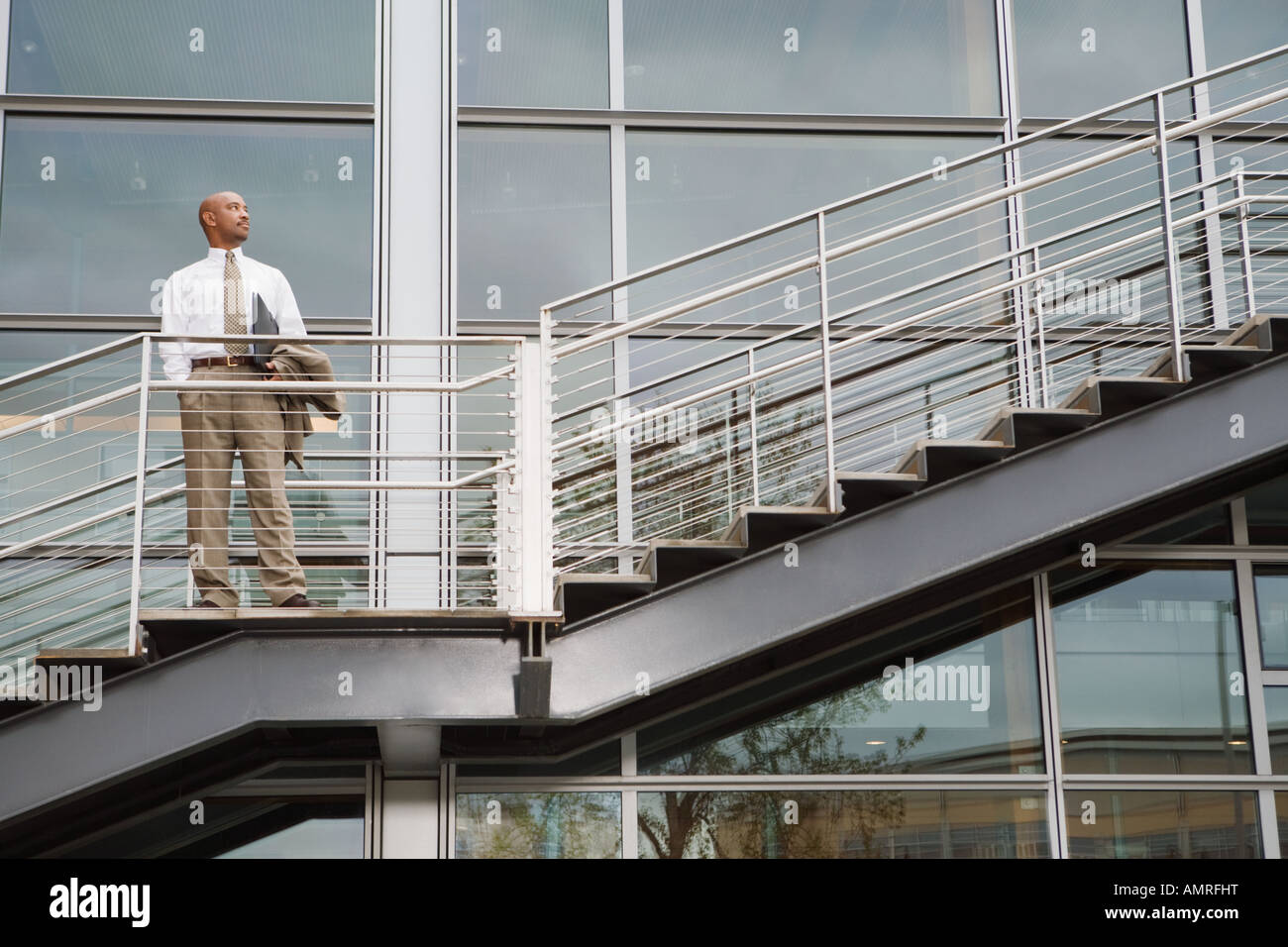 African businessman standing on outdoor staircase Stock Photo