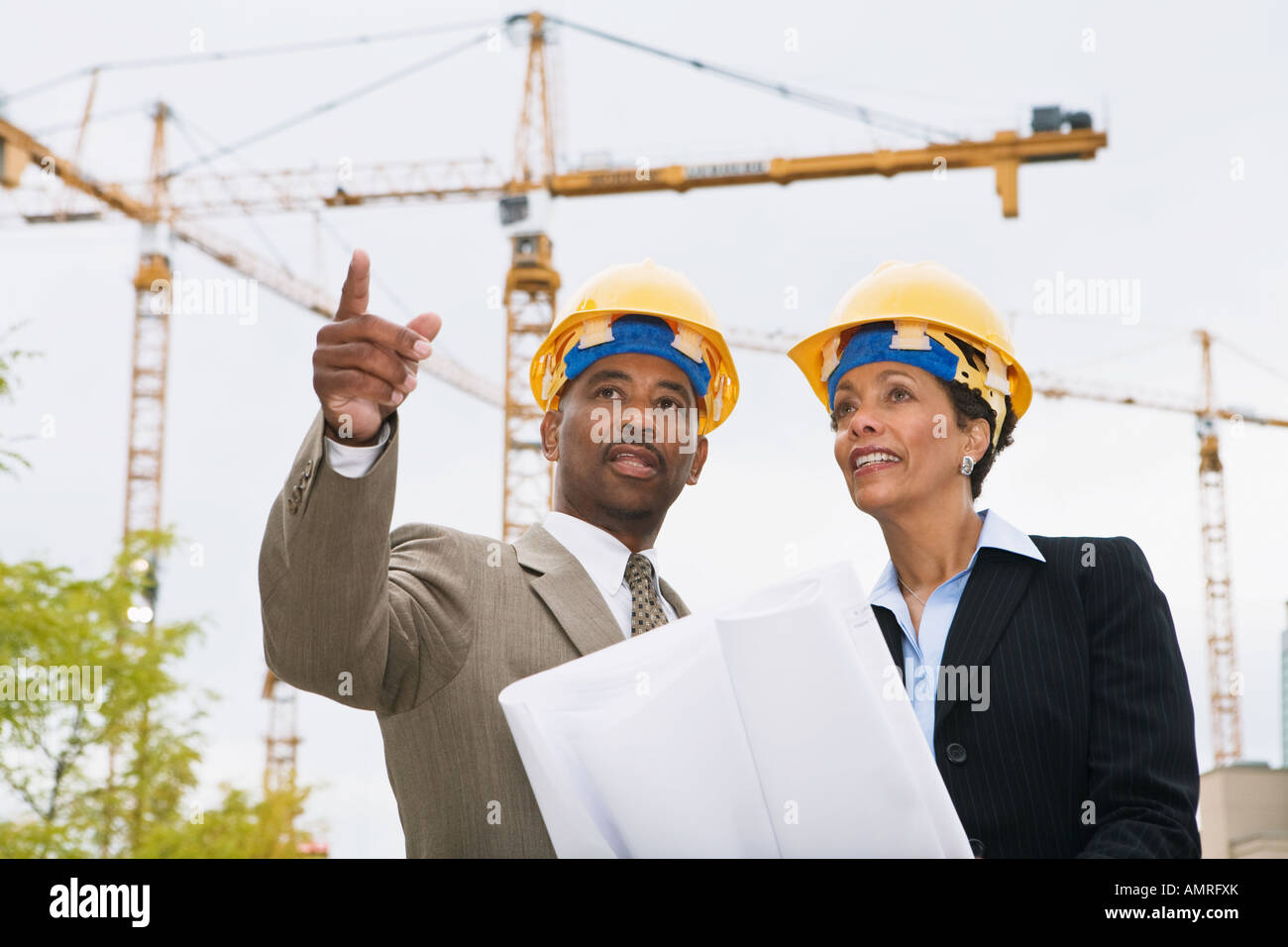 African businesspeople holding blueprints Stock Photo