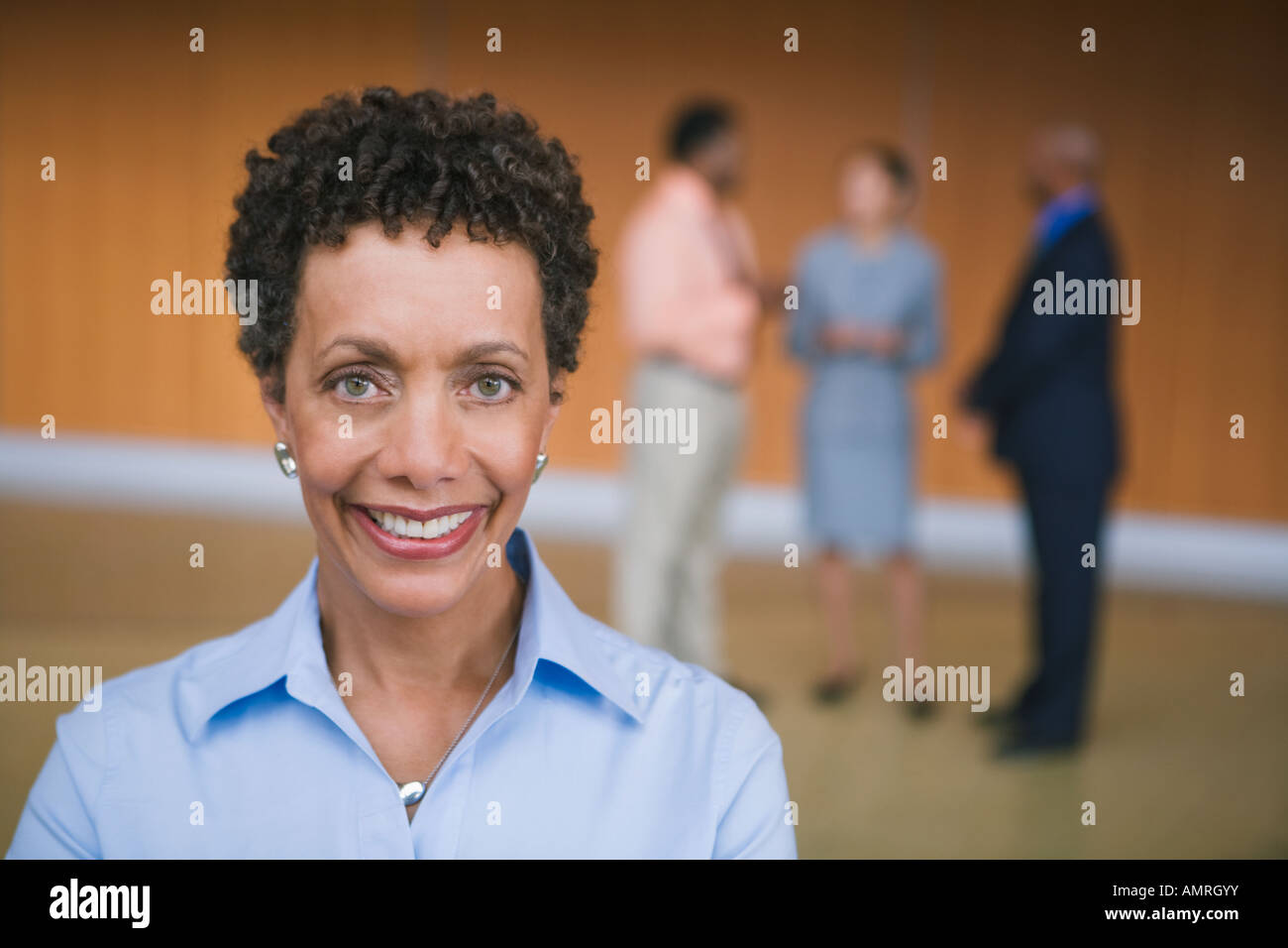 African businesswoman in front of coworkers Stock Photo