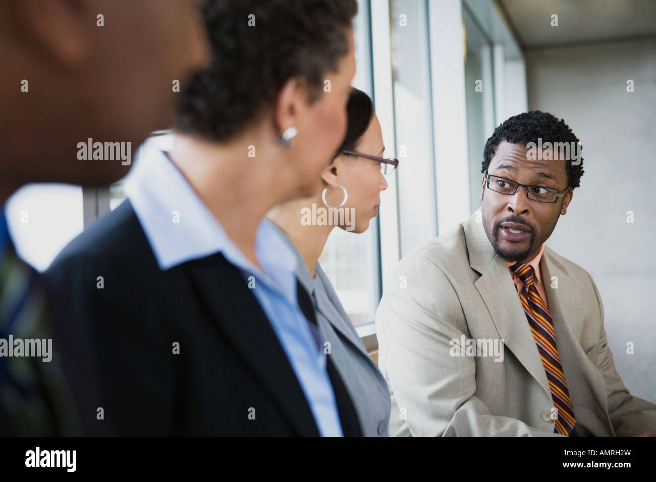 African businessman talking to coworkers Stock Photo