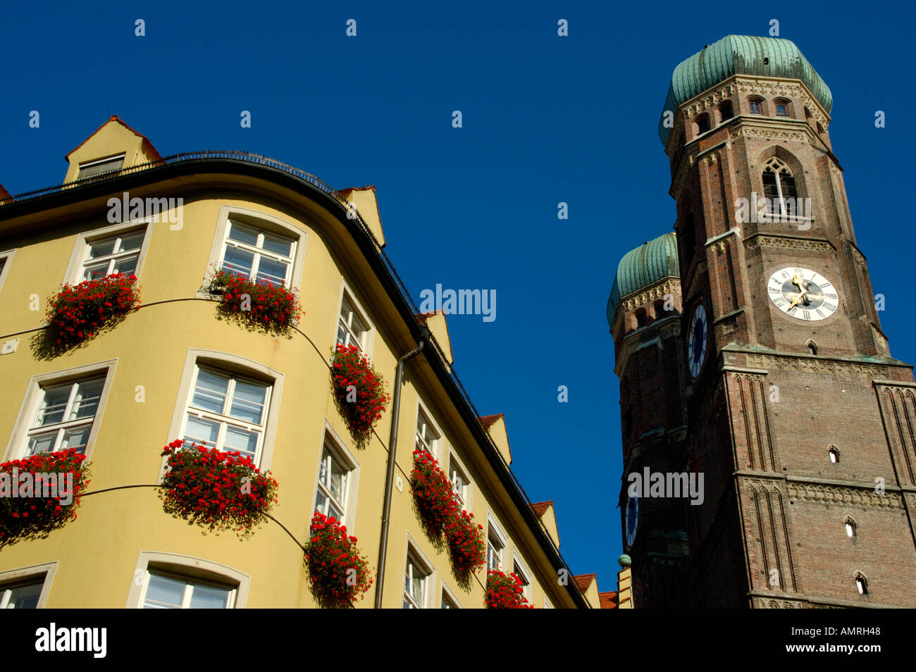 Towers of the church Frauenkirche with a residental house Munich Bavaria Germany Stock Photo