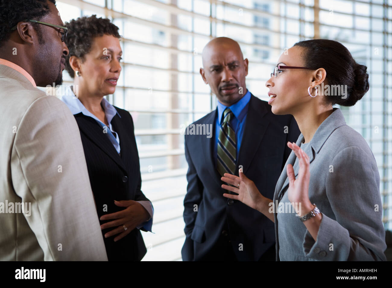 African businesswoman talking to coworkers Stock Photo