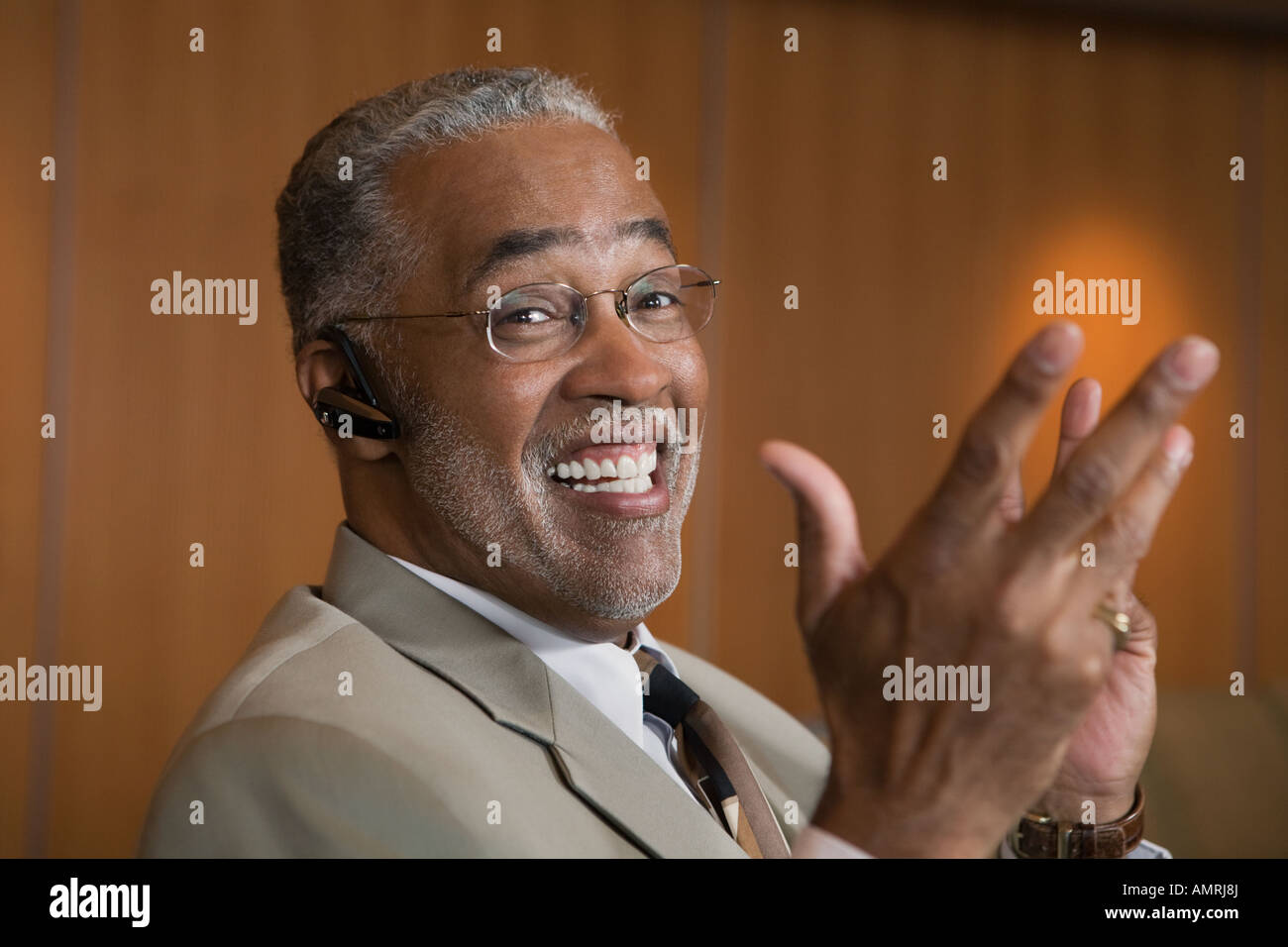Senior African businessman wearing hands-free device Stock Photo
