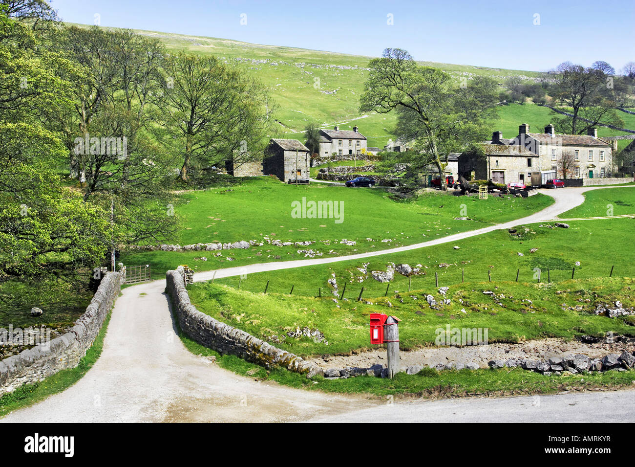 A post box next to a stone bridge and lane leading to Yockenthwaite village in the Yorkshire Dales National Park, UK Stock Photo