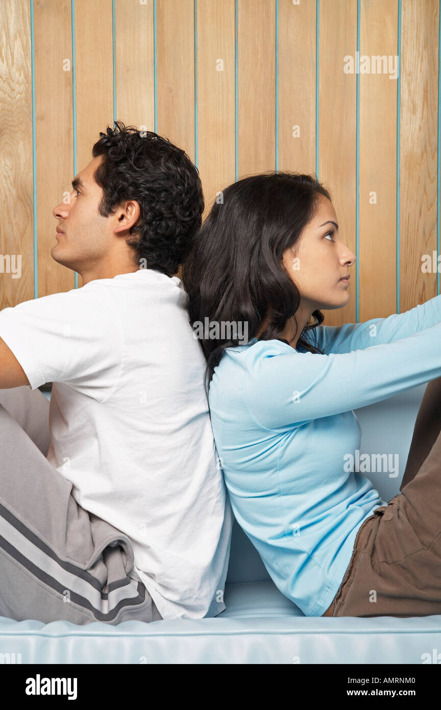 Couple Sitting Back to Back Stock Photo