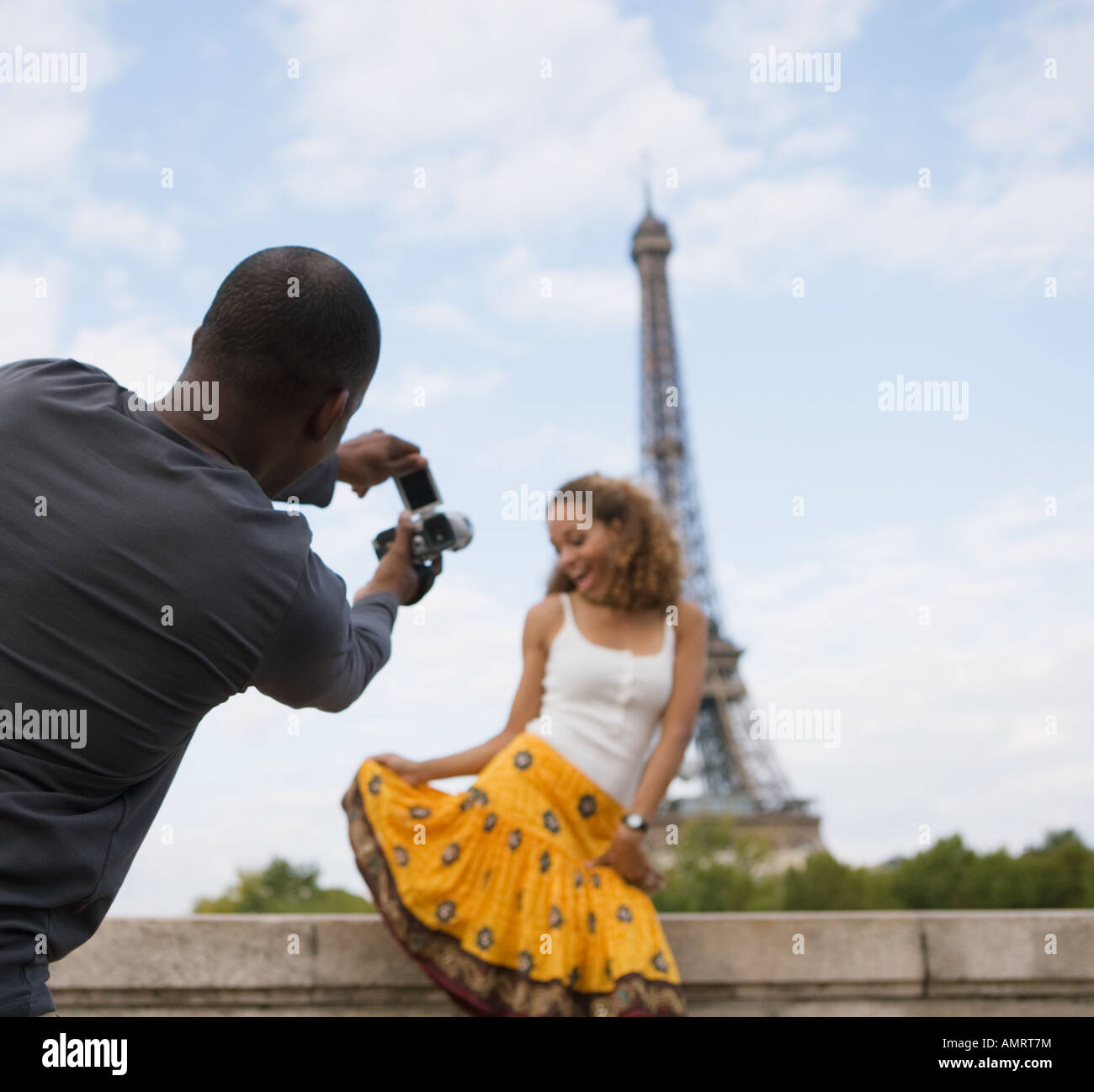 African man taking photograph of girlfriend Stock Photo