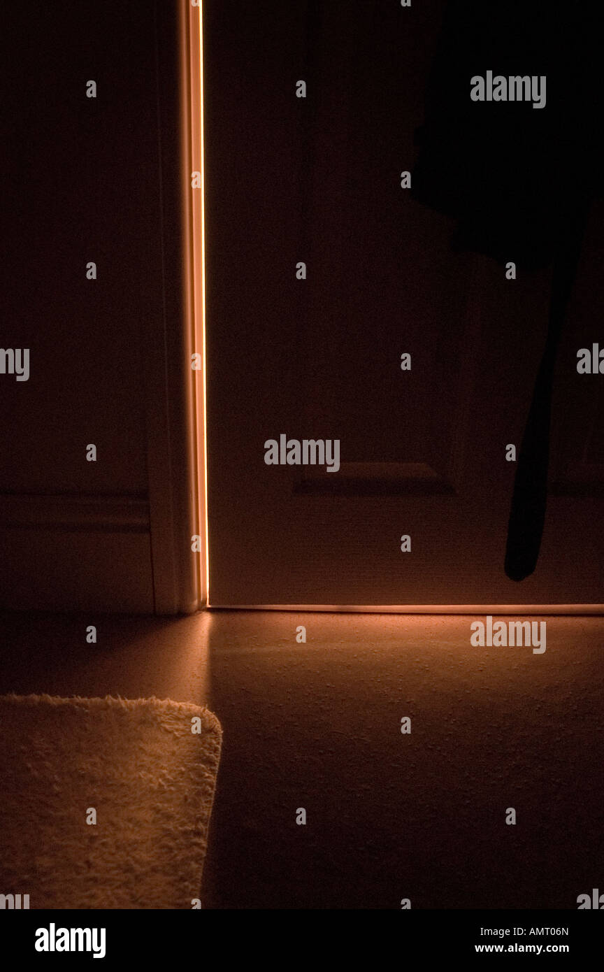 Shaft of light shining under wooden door Stock Photo Alamy