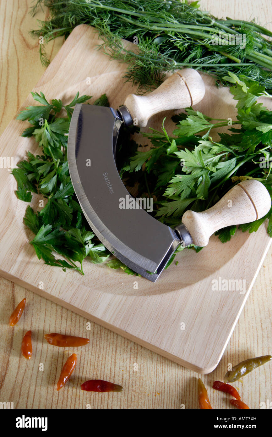 https://c8.alamy.com/comp/AMT3XH/fresh-and-chopped-herbs-and-spices-on-cutting-baord-with-a-mezzaluna-AMT3XH.jpg