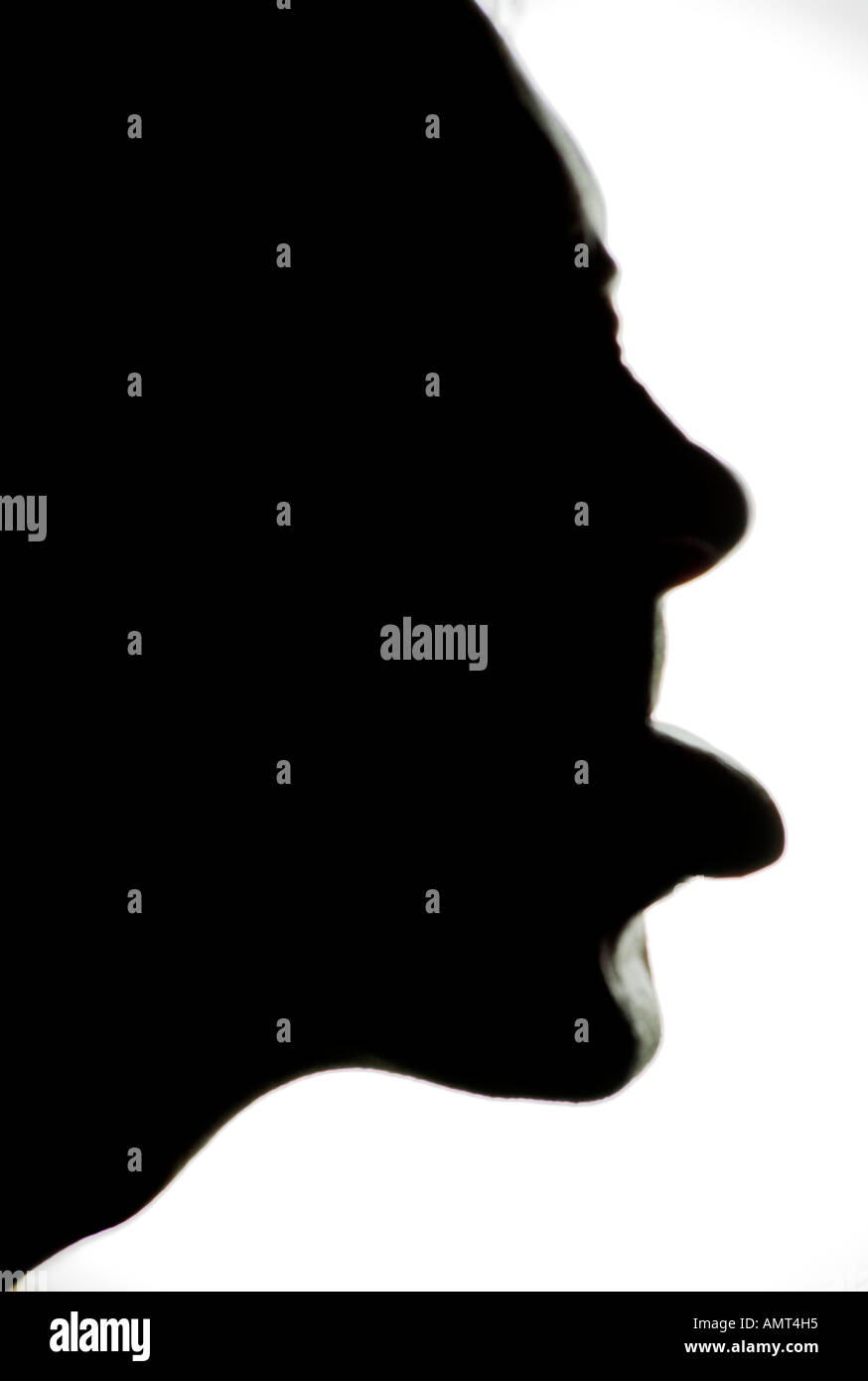 Moody humerous shot of a face profile silhouette with tongue sticking out Stock Photo