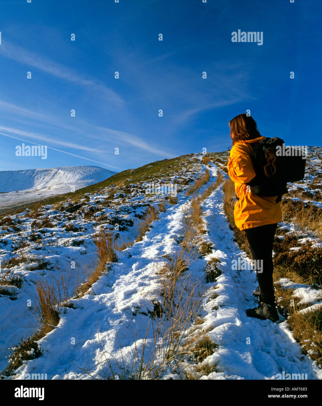 Young woman hillwalking in snowy landscape Stock Photo