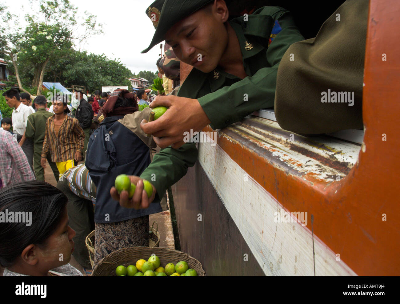 Myanmar Burma Shan State Train trip between Thazi and Kalaw Mindhaik station soldier at train window checking out lemon for sale Stock Photo