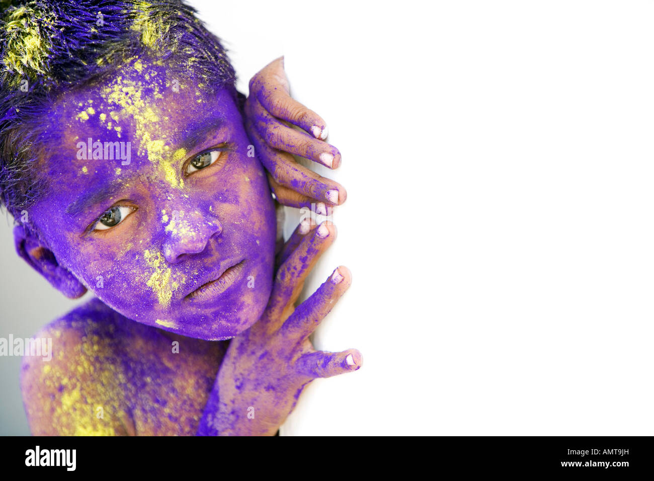 Young Indian boy covered in coloured powder pigment Stock Photo