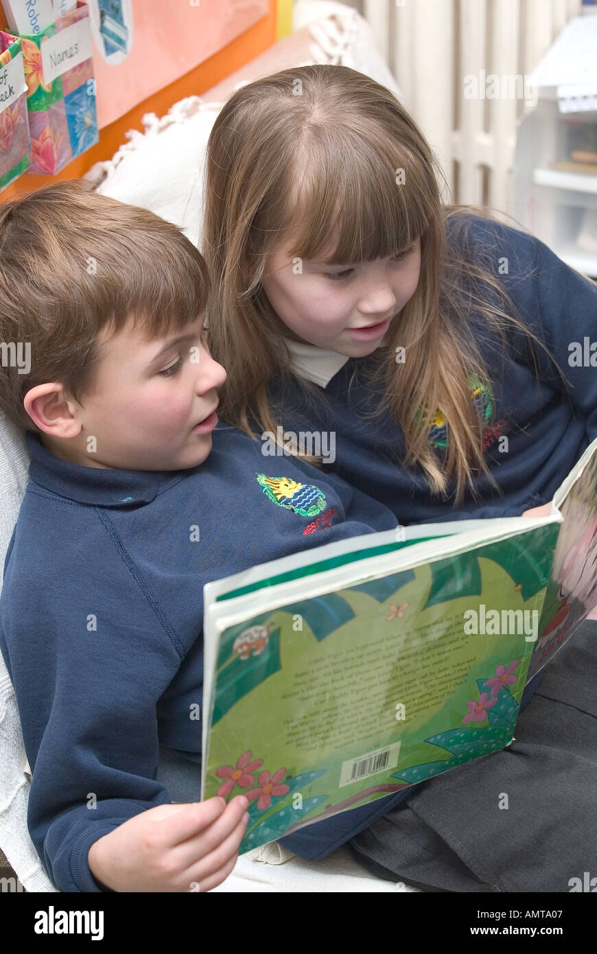 Boy and girl reading a book together at a school in England Stock Photo ...