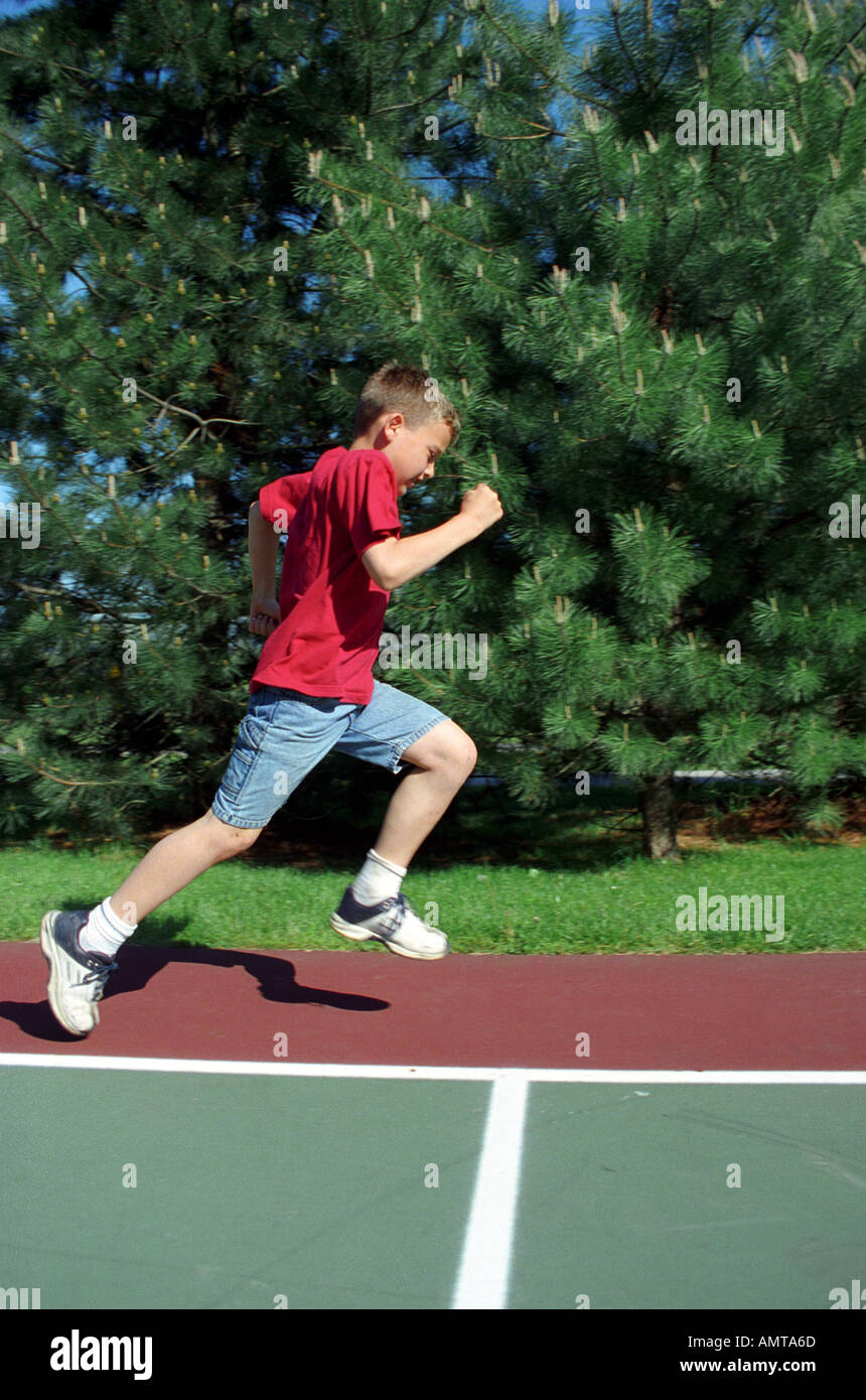 8 year old boy running wearing old tennis shoes Stock Photo