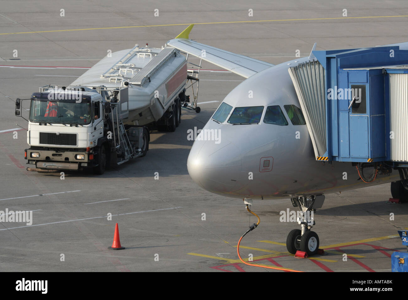 Jet plane refuelling on the ground at airport with fuel truck. Aviation and air transport