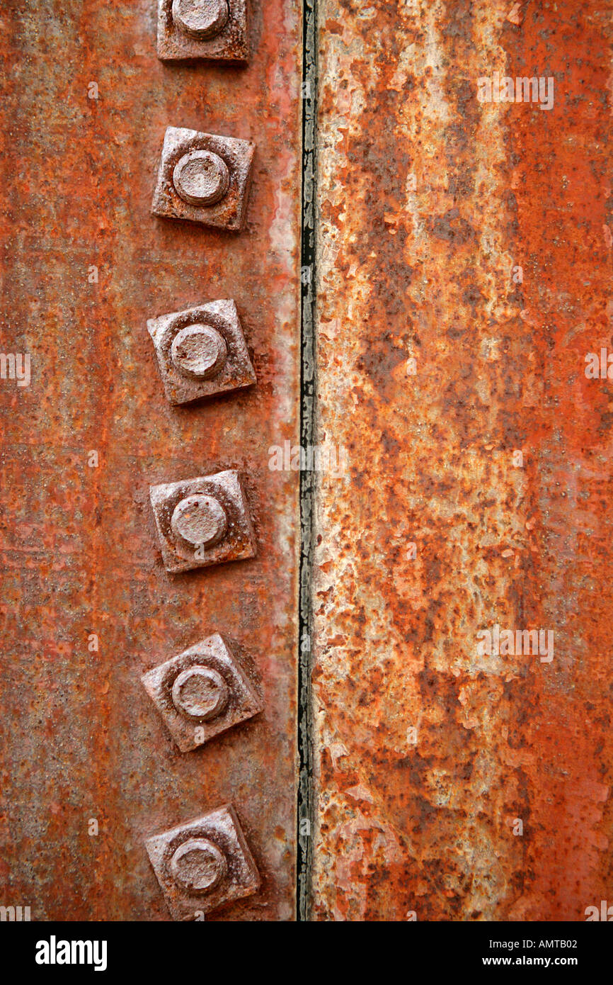 A close up of a seam on an old water tank showing the rust and fastening nuts Stock Photo