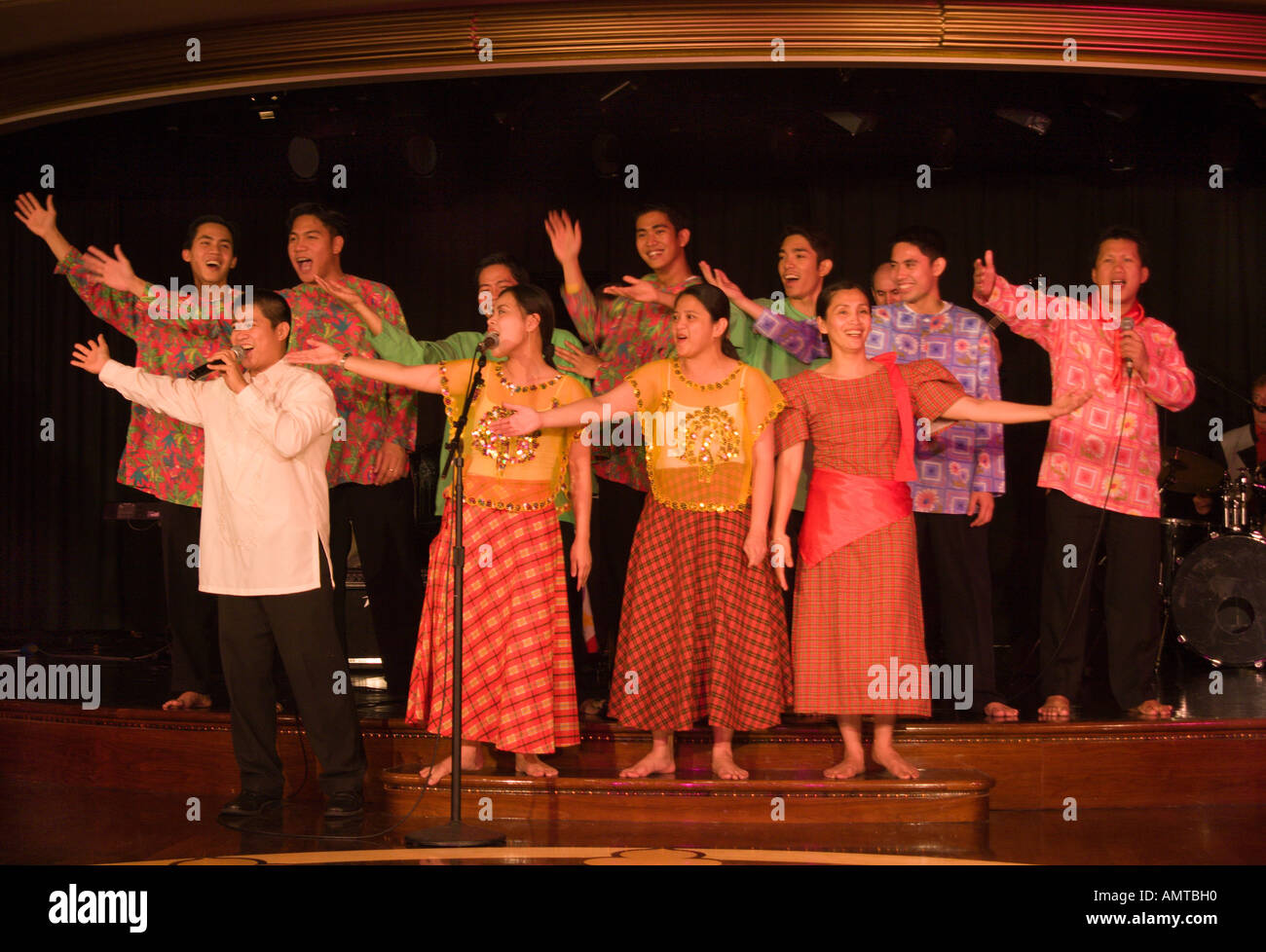 Members of Filipino crew twelve men and women singing and entertaining the passengers on a passenger ship cruise liner Stock Photo